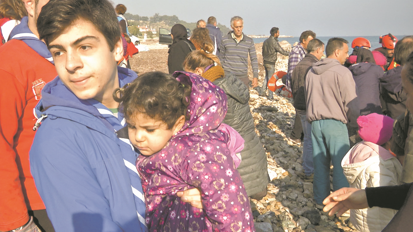 Ο Ξενοφών Κουκούτας με ένα από τα πολλά προσφυγόπουλα που έβγαλαν οι ντόπιοι από τις βάρκες που κατέφθαναν καθημερινά στις ακτές της Λέσβου
